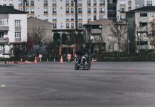 Jak przygotować się do pierwszego szkolenia motocyklowego – praktyczny poradnik dla początkujących Motocyklista ćwiczący slalom między pachołkami na placu w mieście