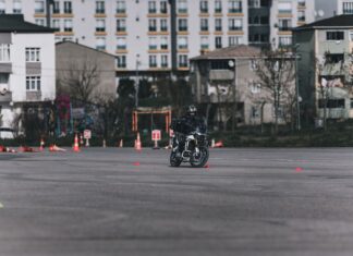 Jak przygotować się do pierwszego szkolenia motocyklowego – praktyczny poradnik dla początkujących Motocyklista ćwiczący slalom między pachołkami na placu w mieście