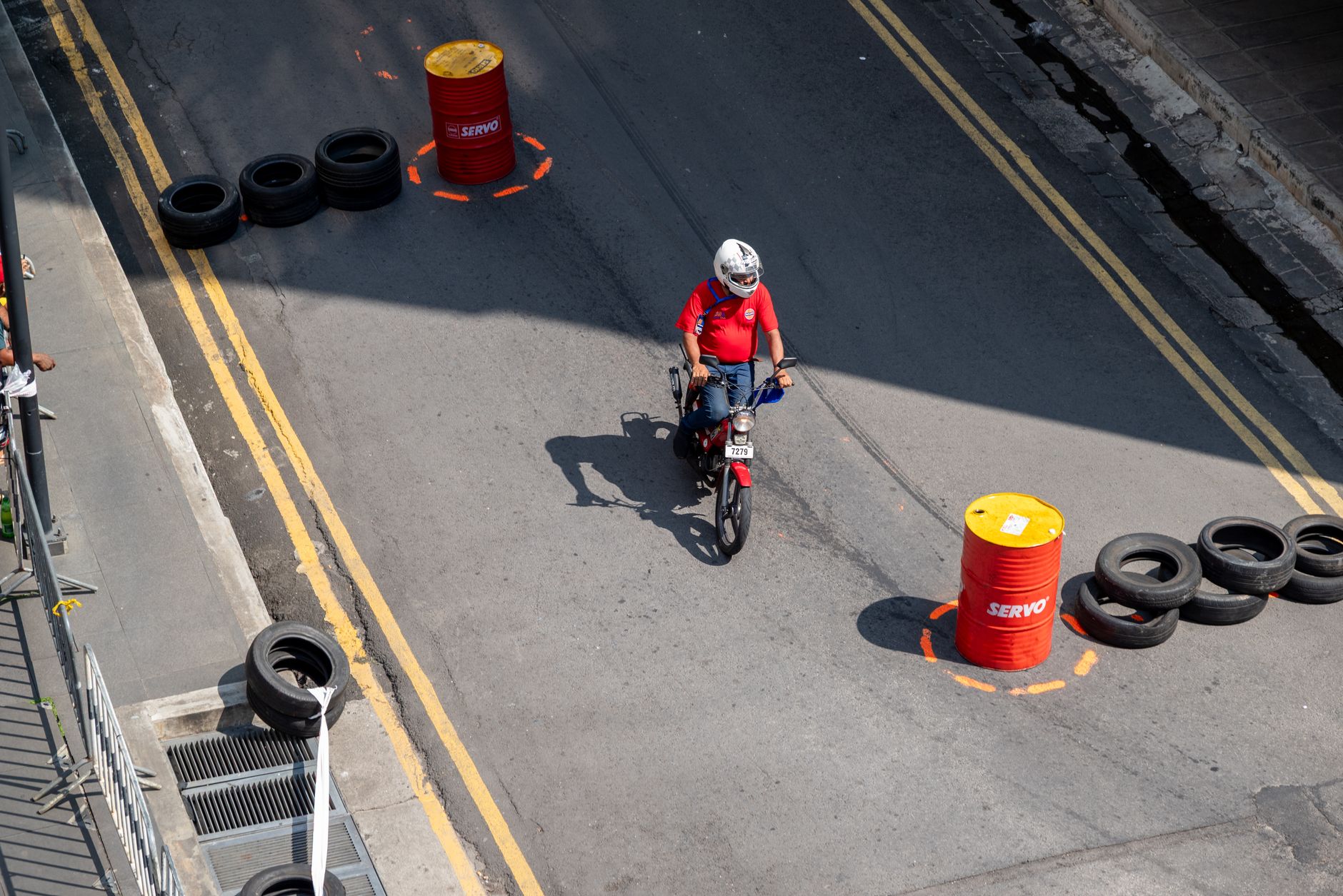 Motocyklista trenuje jazdę po mieście między pachołkami i barierkami