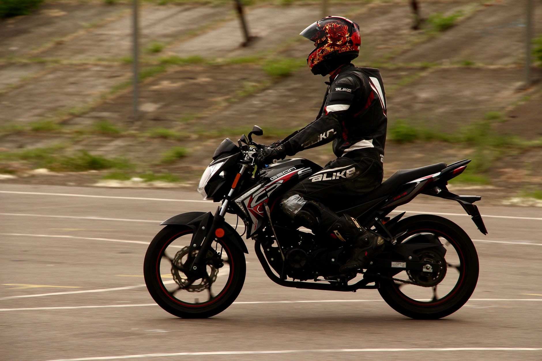 Motocyklista w pełnym stroju ochronnym jedzie sportowym motocyklem po mieście