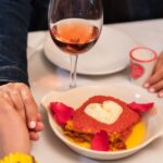 Włoska kolacja przy świecach: menu, które zawsze robi wrażenie Para przy romantycznej włoskiej kolacji przy świecach z sercowym talerzem