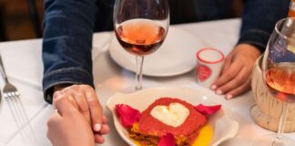Para przy romantycznej włoskiej kolacji przy świecach z sercowym talerzem