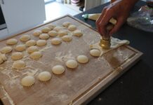 Dlaczego domowe ravioli pękają podczas gotowania i jak temu zaradzić Przygotowywanie domowych ravioli nożem do makaronu na oprószonej mąką desce