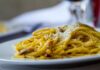 Planowanie włoskiego menu: techniki łączenia makaronu, sosu i dodatków Spaghetti carbonara z tartym parmezanem na białym talerzu