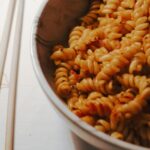 Tanie gotowanie po włosku: aromatyczne dania z kilku prostych składników Miska spirali makaronu przygotowanego do jedzenia w stylu włoskim