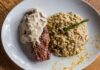 Stek z sosem podany z kremowym risotto grzybowym na talerzu