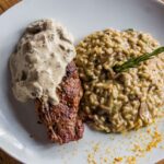 Jak przygotować risotto bez alkoholu, aby zachować głębię smaku i aromatu charakterystyczną dla kuchni włoskiej Stek z sosem podany z kremowym risotto grzybowym na talerzu