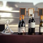 Jak urządzić w domu degustację włoskich win: wybór butelek, przekąski i kolejność podawania Elegancka prezentacja włoskich win z butelkami i karafką na stole