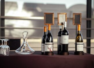Jak urządzić w domu degustację włoskich win: wybór butelek, przekąski i kolejność podawania Elegancka prezentacja włoskich win z butelkami i karafką na stole